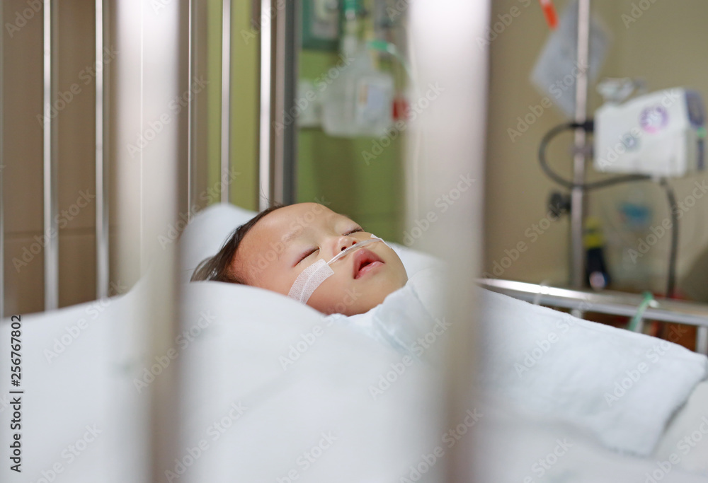 Baby boy with breathing tube in nose receiving medical treatment