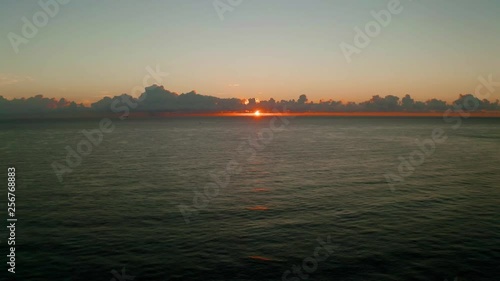 Perfect sunrise on the ocean with the sun glistening over the water. photo