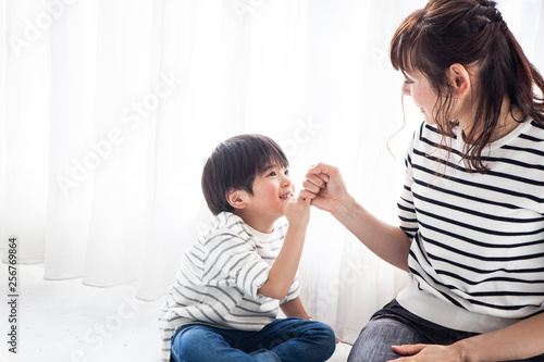 お母さんと楽しそうに指切りする男の子