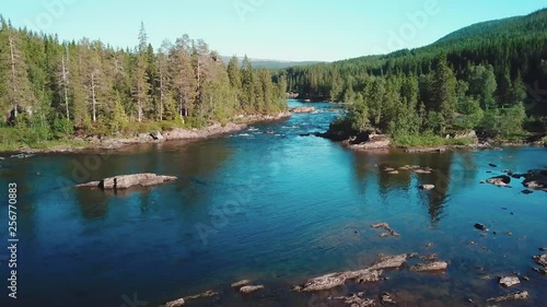 Forward aerial shot over a river in a large forest in mid Norway. Shot in 4K during summer 2018 photo