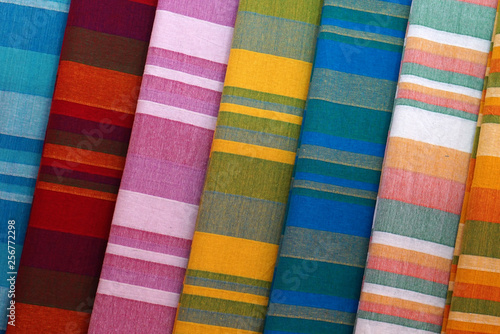 Closeup of folded striped bed sheets in display in a shop, for use as background