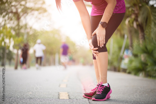 Runner sport knee injury. Woman in knee pain while running work out in park. Health care concept. © Siam