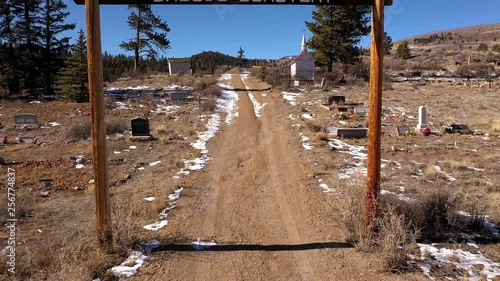 Flight through Creede Cemetery sign toward tombs and monuments. photo