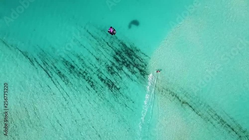 A Kite boarder glides across the turquoise waters of the Turks & Caicos Islands, in a display of warm summer water sports. photo