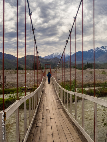 Landscape near Vicuña in Chile with a girl crossing a suspension bridge photo