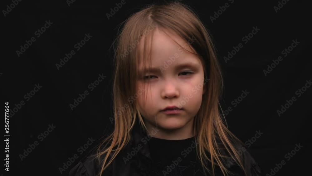 Close-up portrait of a serious sad cute little girl in black clothes Close-up portrait of a serious sad cute little girl in black clothes