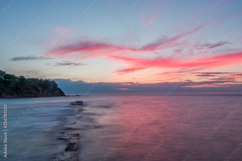 Long Exposure of a Sunset on the Southern Mediterranean Sea in Italy with Ancient Roman Wall
