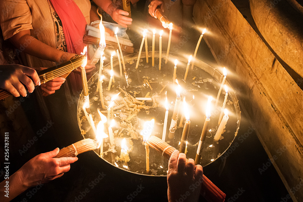 Φωτογραφία Close up of many hands burning candles after the Holy Fire miraculously appeared at Temple of the Lord's Coffin, Jerusalem, Israel