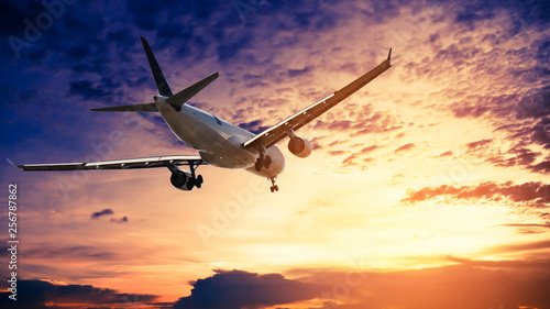 Airplane in the sunset sky flight travel transport airline background concept. © applezoomzoom
