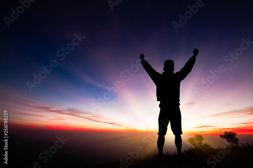 Silhouette of young man standing on the mountain with fists raised up on sunrise background, successful, achievement and winning concept vector illustration