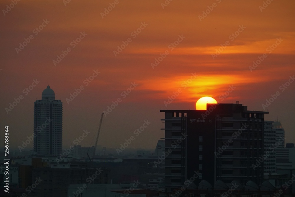 Sunset in Bangkok Thailand. Beautiful sun on the top of the silhouette building and cityscape with top view from the high building on skyscrapers. 