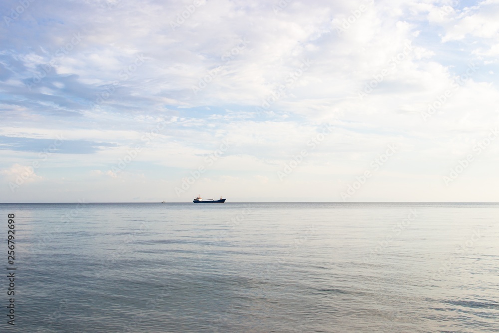 Tranquil seascape with ship at background