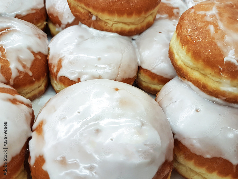 Close-up on a group of fresh donuts with icing for sale in a grocery store or bakery