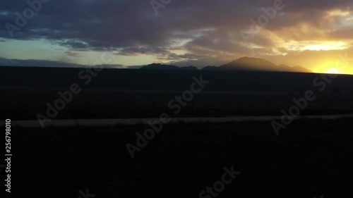 A drone fly's towards the lake dam and rises up to a beautiful sunrise photo