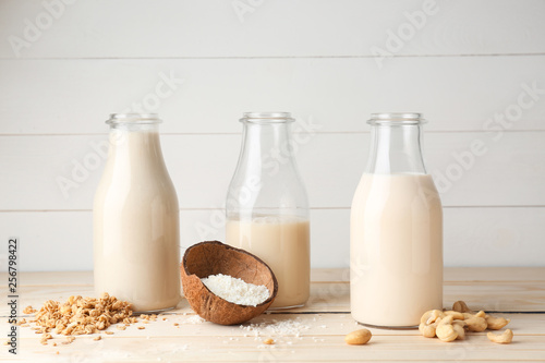 Assortment of tasty vegan milk on wooden table