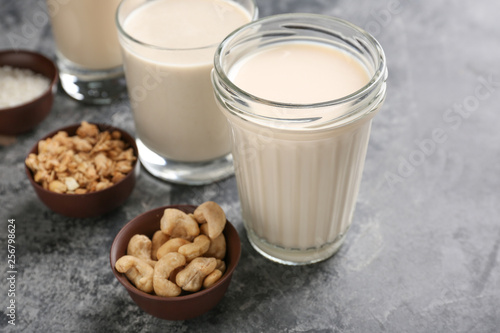 Assortment of tasty vegan milk on grey table