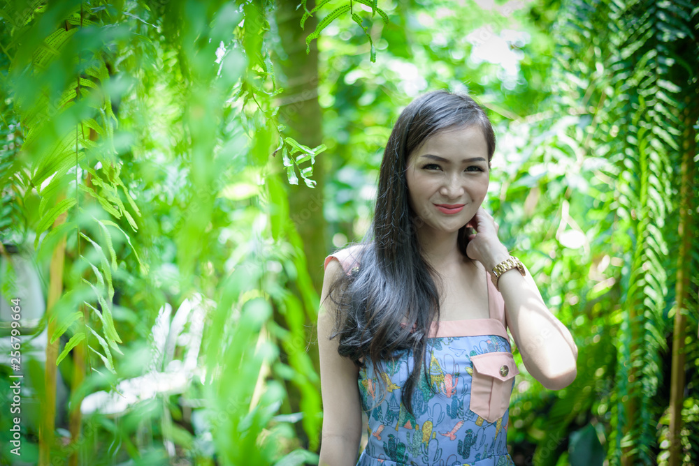 Asian pretty girl has relaxing with happy and smiling at Little Tree Garden cafe, Nakhon Pathom province, Thailand in the morning.