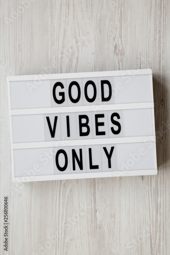 'Good vibes only' words on modern board over white wooden surface, top view. From above, overhead, flat lay.