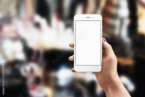 White phone in woman hand with blank, white, isolated screen for app presentation. Free space beside fot text.