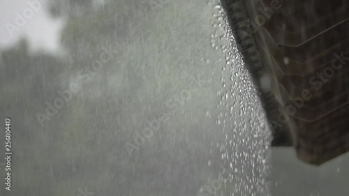 Raindrops from  roof ,HD slow motion. Heavy raining in tropical countryside water from roof dropping down endlessly ,low angle view.