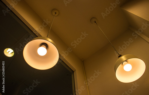 Lighting fixture lamps are hanging on textile classic cable from the ceiling