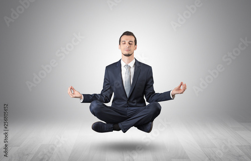 Businessman levitates and sitting in yoga position in an empty infinity space 