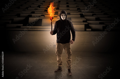 Quadro su tela Ugly, aberrant man coming out from the labyrinth with burning flambeau on his ha