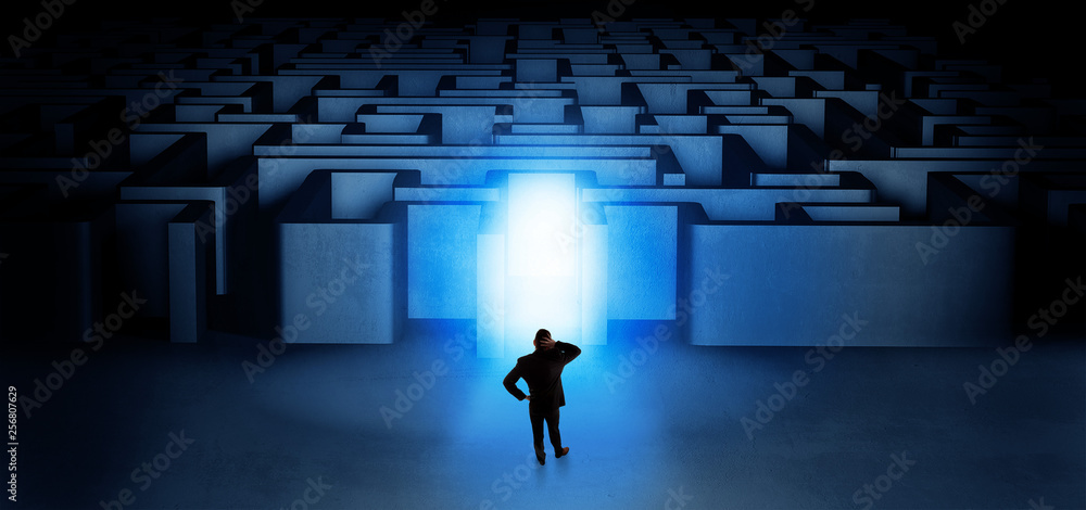 Lost businessman standing at the dark labyrinth with illuminated door
Lost businessman standing at the dark labyrinth with illuminated door