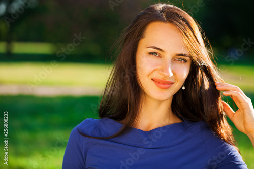 Young brunette woman in summer park photo