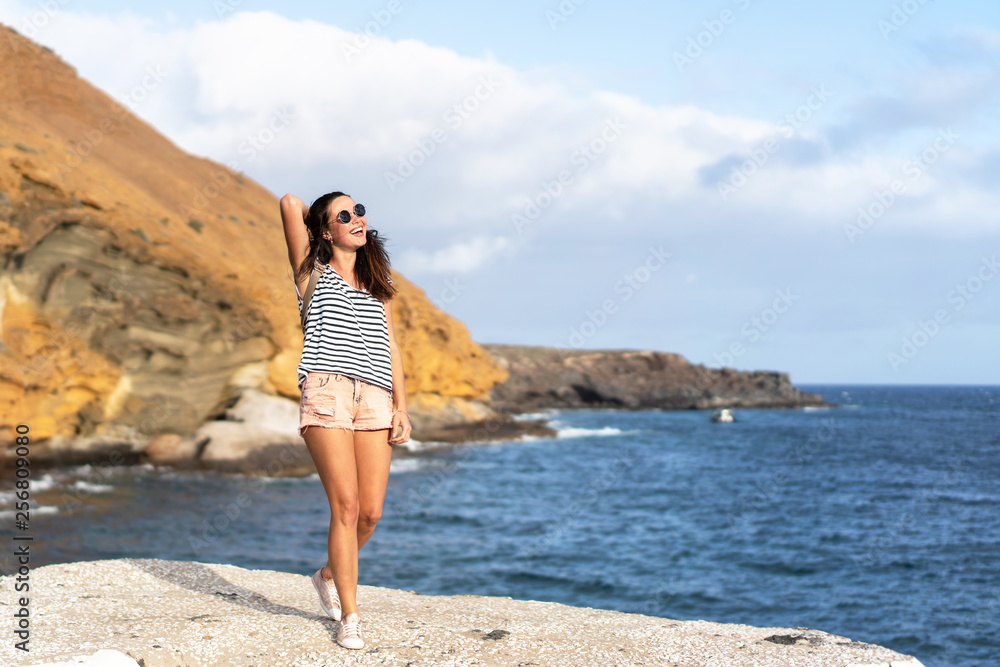 Pretty tourist brunette girl having fun outdoor near sea.