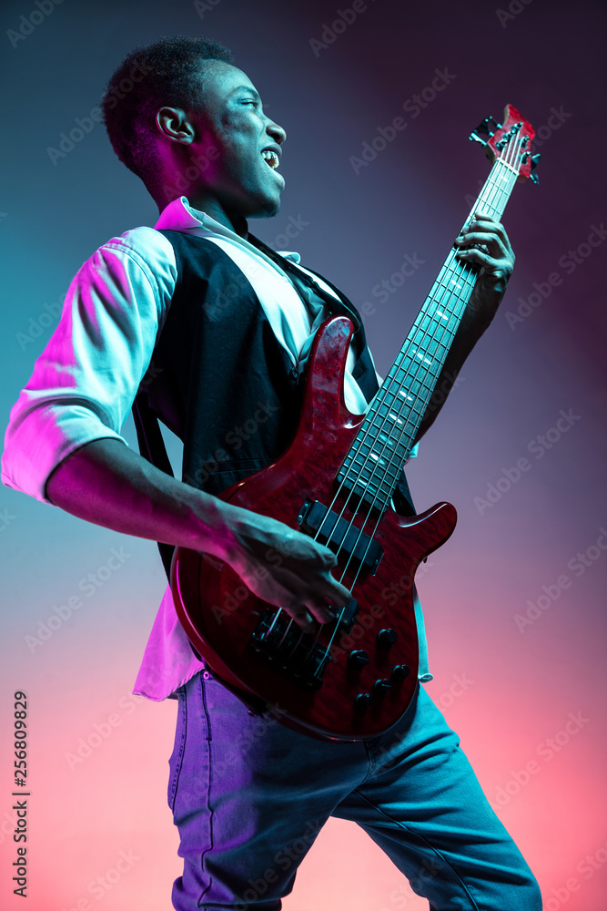 African American handsome jazz musician playing bass guitar in the