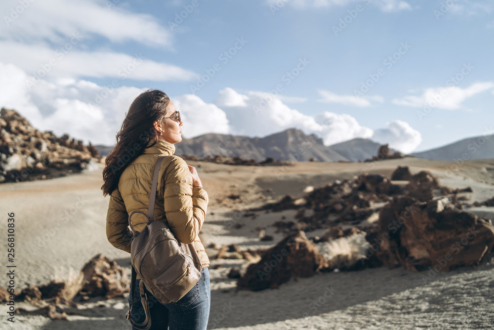 Pretty tourist brunette girl walking near mountains.
