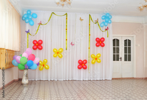 Spacious bright game room in the kindergarten with toys, two large windows and tables for classes. Natural light. photo