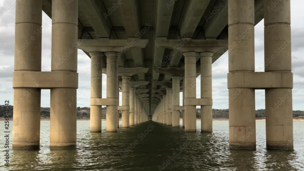 Lake Belton gently flows underneath a symmetrical bridge in Temple, Texas. Lake Belton gently flows underneath a symmetrical bridge in Temple, Texas.