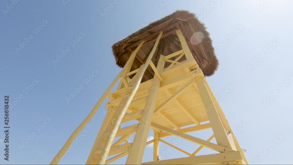 Looking up at a bright yellow rescue tower on a tropical beach. Looking up at a bright yellow rescue tower on a tropical beach.
