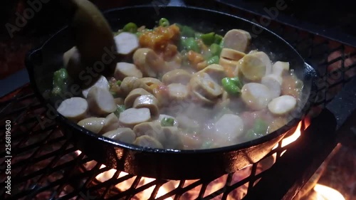 Camp dinner. Preparing food on a camp fire.