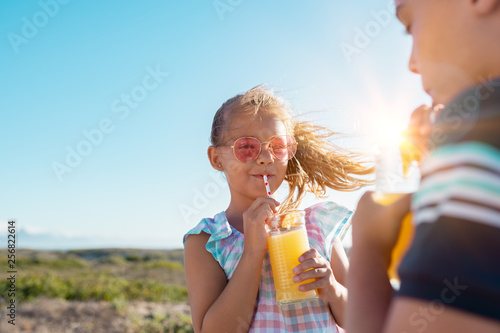 Children drinking orange juice outdoor