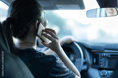 Talking on the phone while driving. Texting and driving. Distracted driver behind the wheel. photo