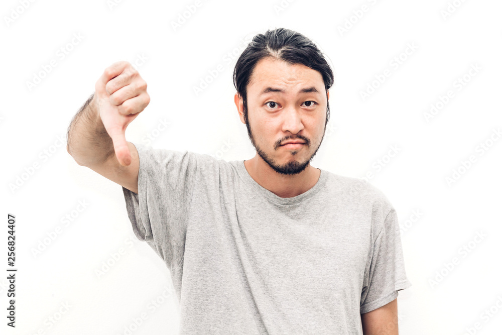 Portrait of happy smiling asian young handsome man with showing thumbs down sign on white background
