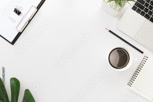 Flay lay, Top view office table desk with keyboard, coffee, pencil, leaves with copy space white background.