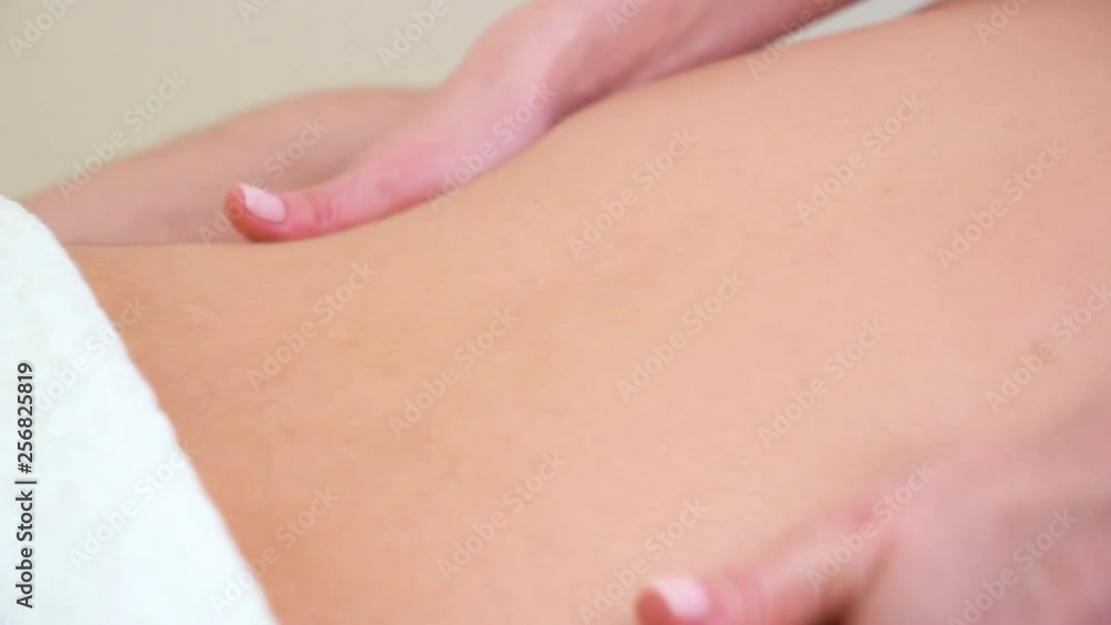 closeup of female hands doing relaxing massage on male back in spa salon closeup of female hands doing relaxing massage on male back in spa salon