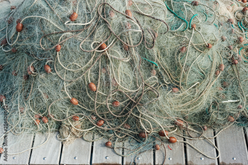 Nylon fishing net with buoys on wooden background Nylon fishing net with buoys on wooden background