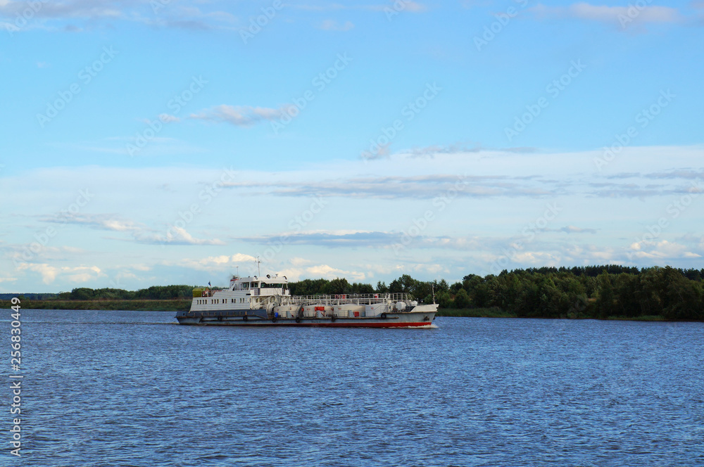 Cargo ship goes along the Volga river, Russia. Summer evening