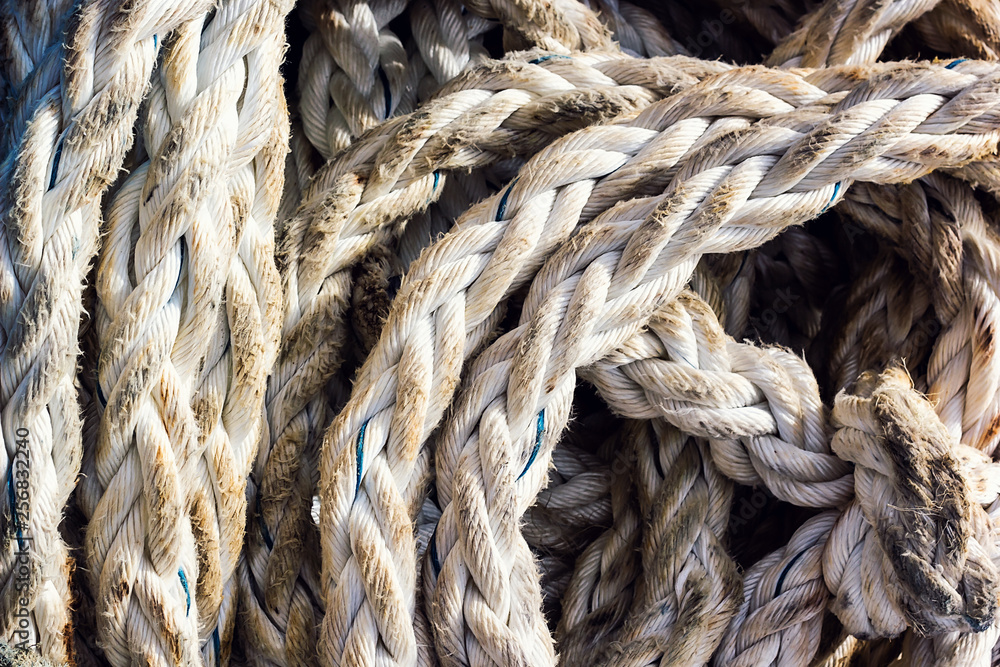 Frayed boat rope. Massive nautical dirty shabby white ropes background  texture close up. Detail of old used coiled jute ship seaman's rope.  Fishing or boat accessories. Image. Stock Photo