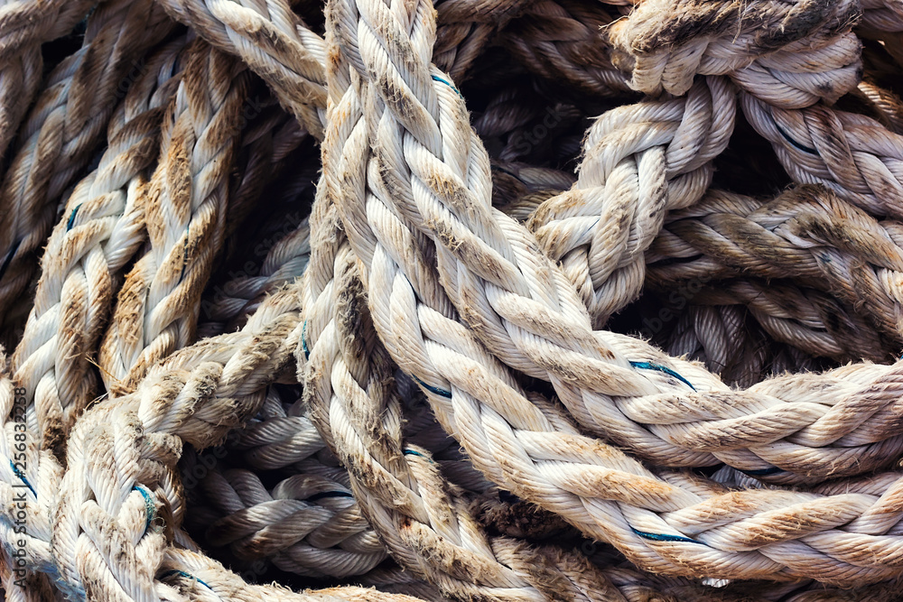 Frayed boat rope. Massive nautical dirty shabby white ropes background texture close up. Detail of old used coiled jute ship seaman's rope. Fishing or boat accessories. Image.