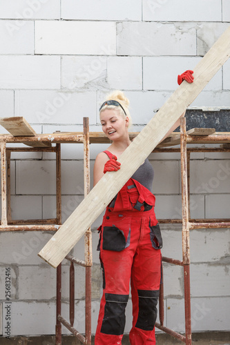 Εκτύπωση καμβά Woman carrying plank boards on construction site