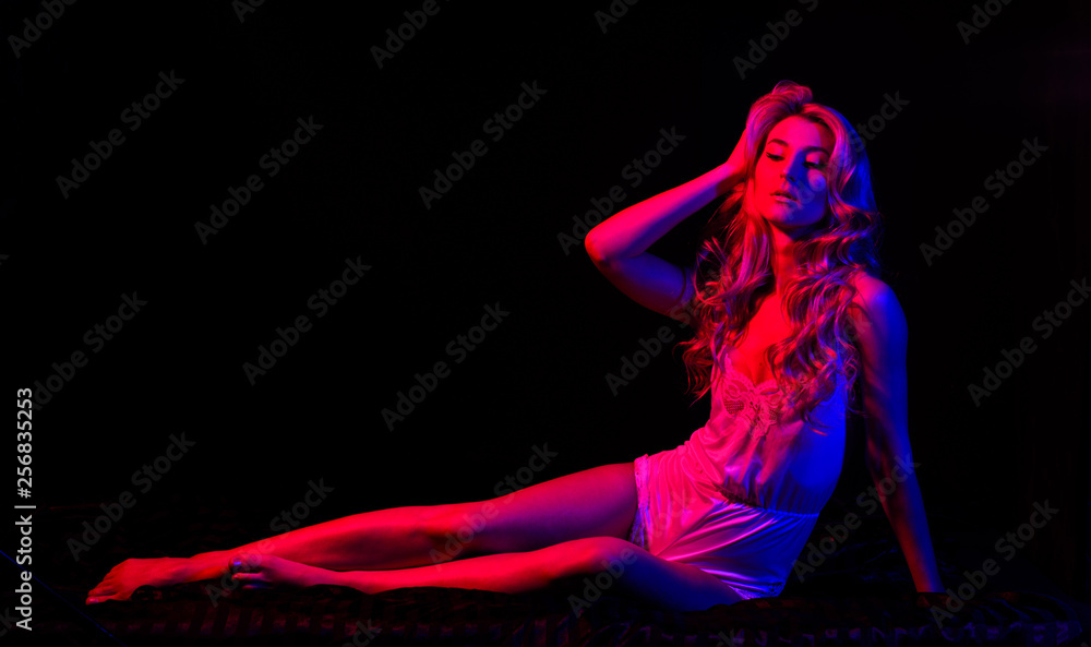 Sexy slumber. Time to relax. Fashion beauty. Blond curly hair. Pinup look. Sensual girl with fit body in red light. Pin up woman in bodysuit relax in bed. Sexy woman in erotic lingerie. relax of girl