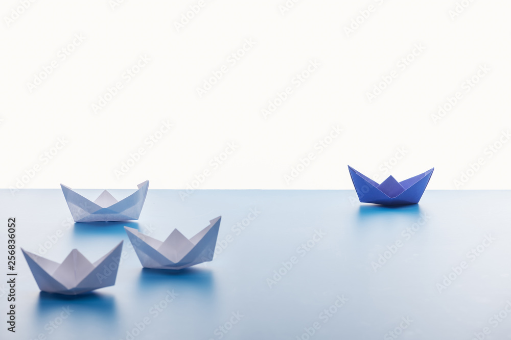 Paper boats on light blue surface on white background Paper boats on light blue surface on white background