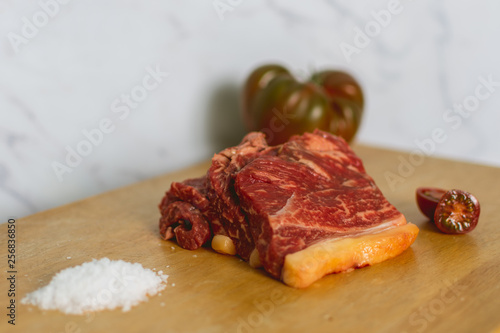 fresh raw beef meat steak slices on wooden cut board over white background photo