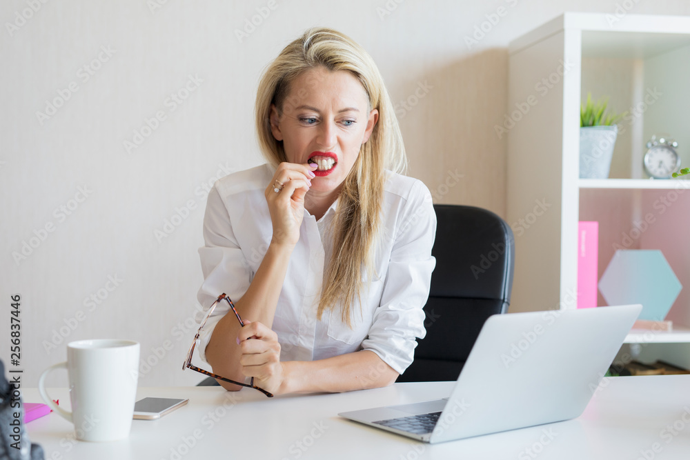 Woman biting her nails in office